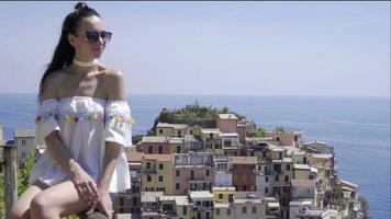 junge frau mit schöner aussicht auf das alte dorf in cinque terre, ligurien, italien. europäisch italienischer urlaub. video