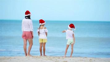 famiglia nel Natale cappello su bianca spiaggia durante natale vacanza video