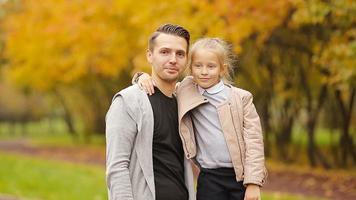 Portrait of little girl and happy father enjoy fall day in autumn park outdoors. Autumn family vacation video