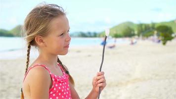 schattig klein meisje op het strand met veel plezier. slow motion video