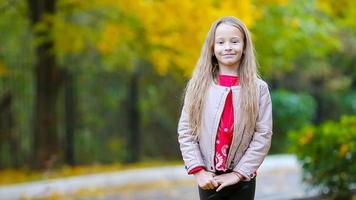 Portrait of adorable little girl in fall looking at camera and smiling video