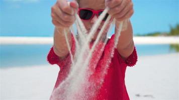 schleppend Bewegung schließen hoch. Mädchen spielen mit schön Weiß Sand beim tropisch Strand video