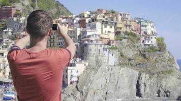 jong Mens nemen een foto van mooi visie Bij oud dorp in cinque terrein, ligurië, Italië. Europese Italiaans vakantie. video