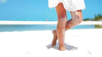 lent mouvement proche en haut. fille en jouant avec magnifique blanc le sable à tropical plage video