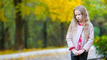 retrato de triste pequeño niña en otoño mirando a cámara y sonriente video