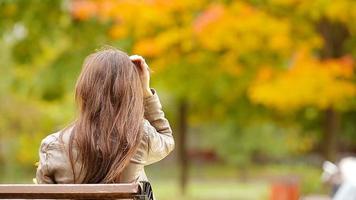 magnifique femme prendre plaisir chaud journée dans l'automne parc en dessous de tomber feuillage video