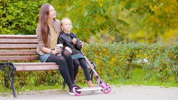 adorable peu fille avec mère prendre plaisir tomber journée dans l'automne parc en plein air video