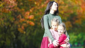 Family of mom and kids in fall. Young mother and little girls enjoy warm autumn video