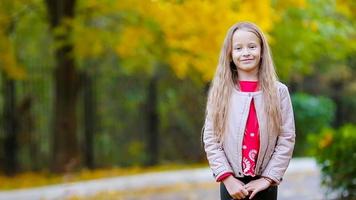 schattig klein meisje buitenshuis op mooie herfstdag video