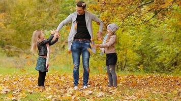 Happy family having fun and throwing leaves around on an autumn day outdoors video