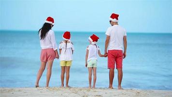 contento familia con dos niños en Papa Noel sombrero en verano vacaciones celebrar Navidad video