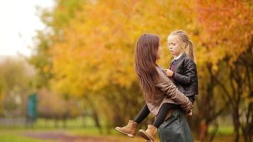 adorable peu fille avec mère prendre plaisir tomber journée dans l'automne parc en plein air video