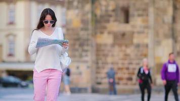 Happy young woman with a city map in Europe. Travel tourist woman with map in historic place outdoors during holidays video