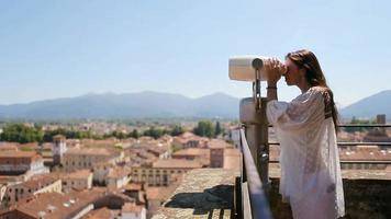 magnifique fille à la recherche à pièce de monnaie opéré binoculaire sur terrasse à petit ville dans toscane, Italie video