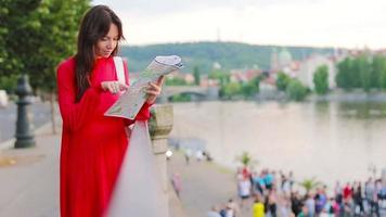 gelukkig jong vrouw met een stad kaart in Europa achtergrond beroemd brug. reizen toerist vrouw met kaart buitenshuis gedurende vakantie in Europa.