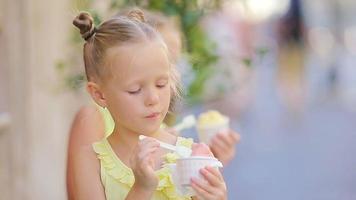 adorabile poco ragazza mangiare gelato all'aperto a estate. carino ragazzo godendo vero italiano gelato vicino gelateria nel Roma