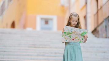 adorable petite fille avec carte touristique dans les rues romaines en italie. heureux enfant de toodler profite de vacances italiennes en europe. video