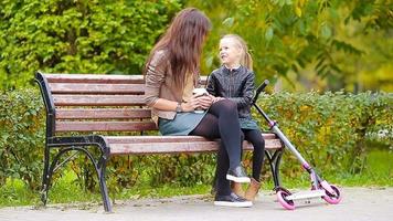 Adorable little girl with mom enjoy fall day in autumn park outdoors video