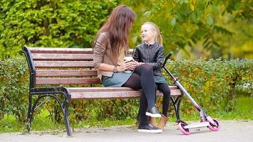 entzückendes kleines mädchen mit mama genießt den herbsttag im herbstpark im freien video