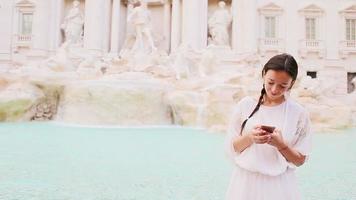 jung Frau mit Clever Telefon beim warm Tag draußen im europäisch Stadt in der Nähe von berühmt Fontana di trevi video