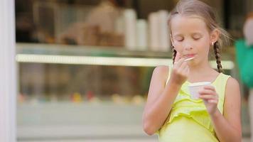 adorable niña comiendo helado al aire libre en verano. lindo niño disfrutando del verdadero helado italiano cerca de heladería en roma video