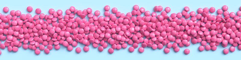 Wide border of pink coated chocolate candies on blue pastel background. 3d rendering photo