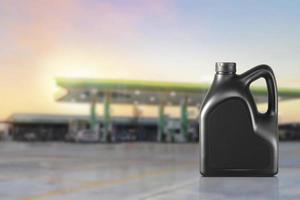 bottle of engine oil nozzle against with gas station blurred background photo