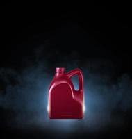 Red bottle of engine oil on black background with smoke photo