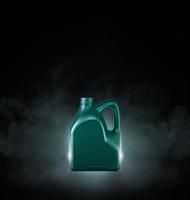 Green bottle of engine oil on black background with smoke photo