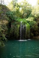 Long exposure waterfall during the day. green forest and rocky mountain. summer time. crystal clear blue water. beautiful waterfall with blue lake in the forest. photo