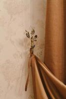 golden holder for room curtains. Fragment photo curtain, interior detail, curtain detail close up