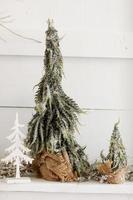 Christmas composition. Two Christmas fir trees with burlap and artificial snow, on wooden white rustic background. Merry Christmas, New Year, Happy Holidays, Template. Greeting card. 2023 photo