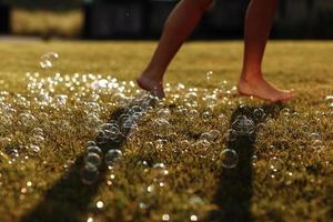 barefoot on a green lawn with soap bubbles photo