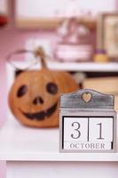 Víspera de Todos los Santos fiesta antecedentes con calabaza y calendario con 31 octubre en de madera mesa en colegialas habitación. foto