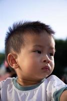 cerca arriba retrato de asiático chico en el puesta de sol foto