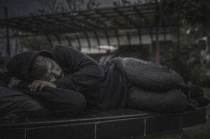 Asian man is homeless at the side road,A stranger has to live on the road alone because he has no family. photo