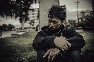 un hombre asiático no tiene hogar en la calle lateral, un extraño tiene que vivir solo en la calle porque no tiene familia. foto