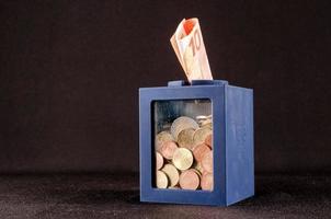 Coins and Euro banknote in a box photo