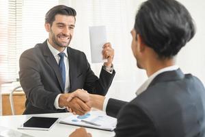 Handshake, caucasian male giving financial reward in an envelope, business letter extra salary to company employee, asian manager man worker office hand received premium bonus,getting cheque from boss