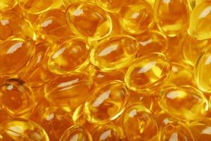 Primer plano de cápsulas doradas de vitamina omega 3 aceite de pescado foto