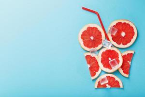 A composition of grapefruit slices and ice cubes with a blue background in the form of a refreshing drink photo