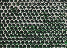 A wall of green wine bottles. Solid texture fence from the bottom photo