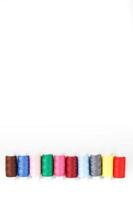 Colorful cotton craft sewing threads multicolored in a row isolated on a white background. photo