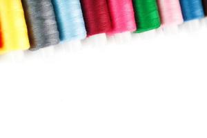 Colorful cotton craft sewing threads multicolored in a row isolated on a white background. photo