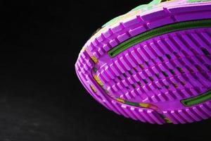 Textured pink sole of sports running shoes on a black background. photo