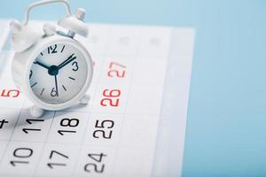 el blanco alarma reloj es en el calendario con fechas foto