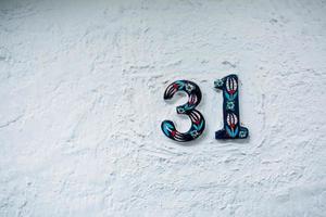 The number 31 is the house number on the white ceramic wall. Old central street. photo