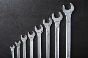 A set of wrenches in a row on a black background in a row. photo