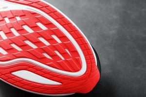 primer plano de la suela de una zapatilla deportiva para correr en rojo foto