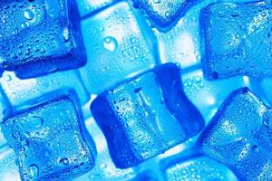 Ice cubes with blue backlight in the freezer close-up in full screen photo